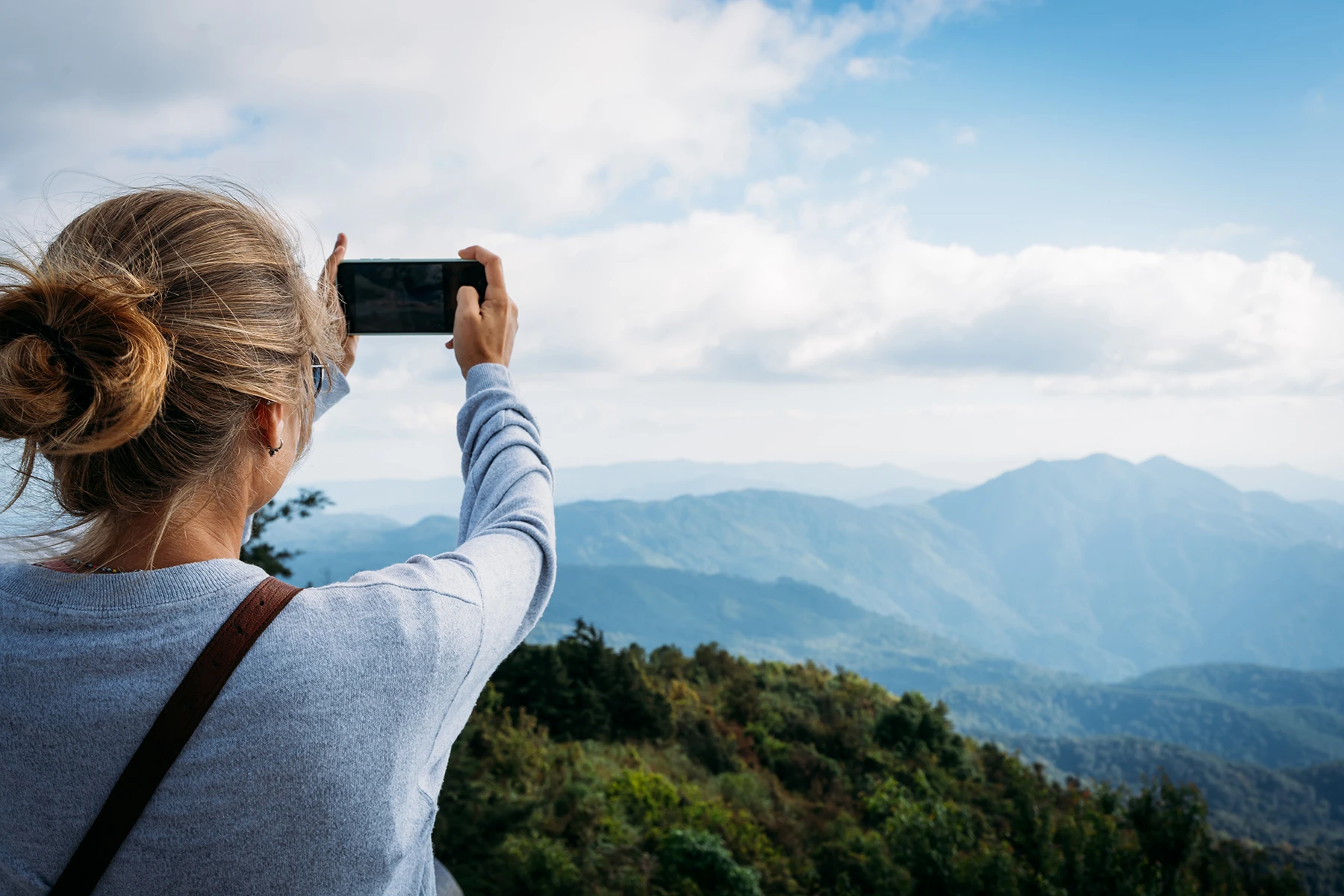 woman taking picture at an overlook of the Great Smoky Mountains